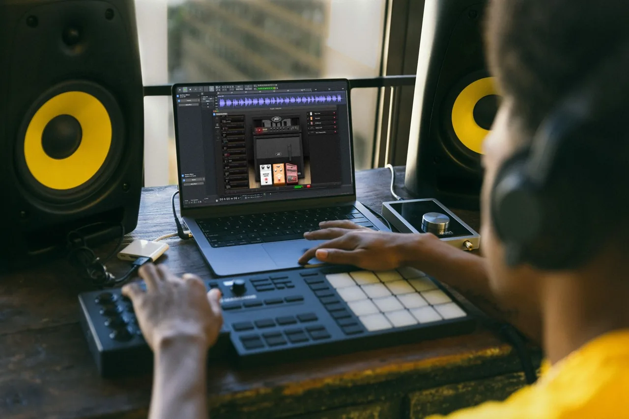 Produtor usando efeitos do Audacity em notebook de estúdio